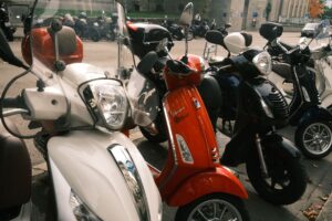 Rangée de petits scooters et cyclomoteurs garés en extérieur